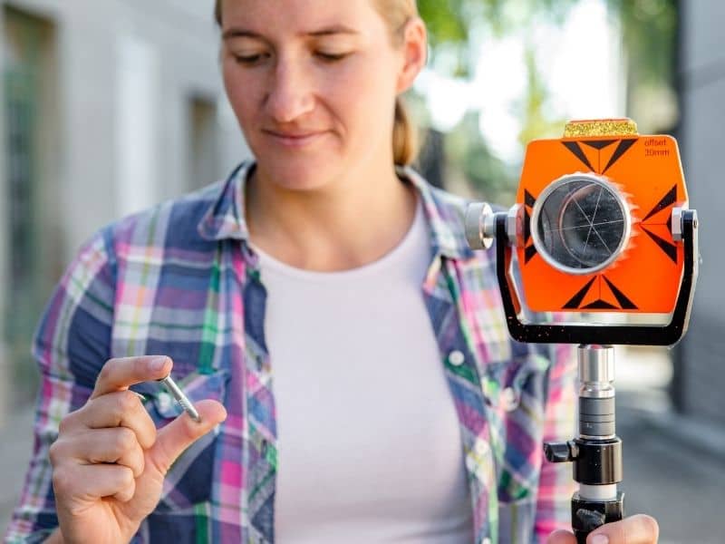 Surveyor locating a property corner marker during a boundary survey